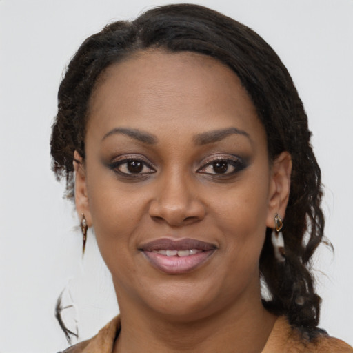 Joyful black young-adult female with long  brown hair and brown eyes