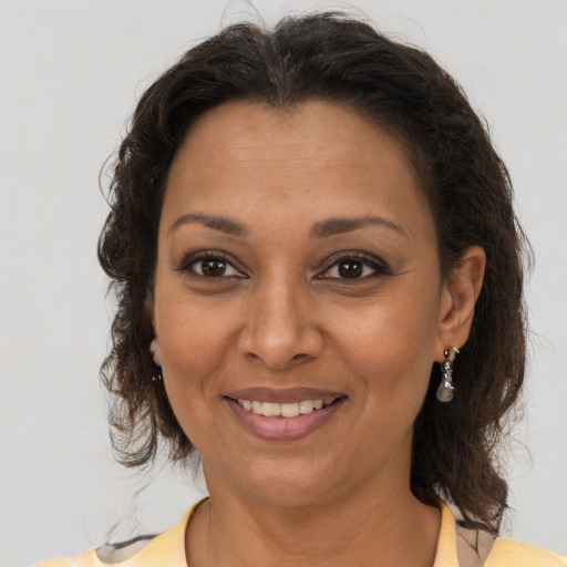 Joyful black adult female with medium  brown hair and brown eyes