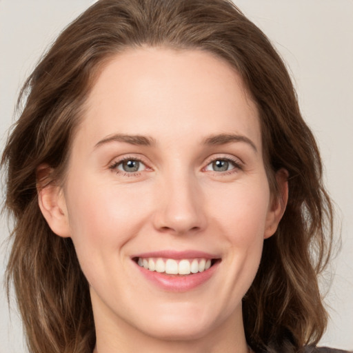 Joyful white young-adult female with medium  brown hair and green eyes