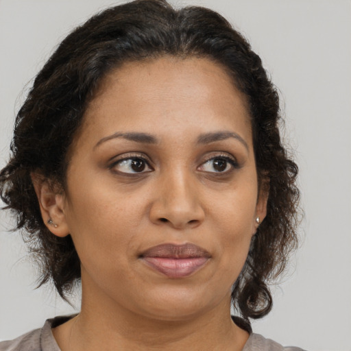 Joyful black adult female with medium  brown hair and brown eyes