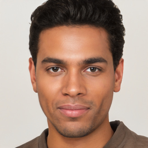 Joyful latino young-adult male with short  brown hair and brown eyes