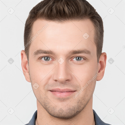 Joyful white young-adult male with short  brown hair and grey eyes