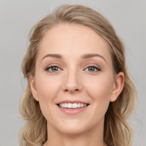 Joyful white young-adult female with long  brown hair and blue eyes