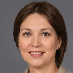 Joyful white adult female with medium  brown hair and grey eyes