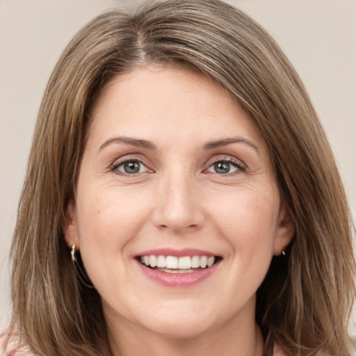 Joyful white young-adult female with long  brown hair and grey eyes