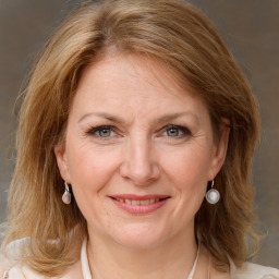 Joyful white adult female with medium  brown hair and blue eyes