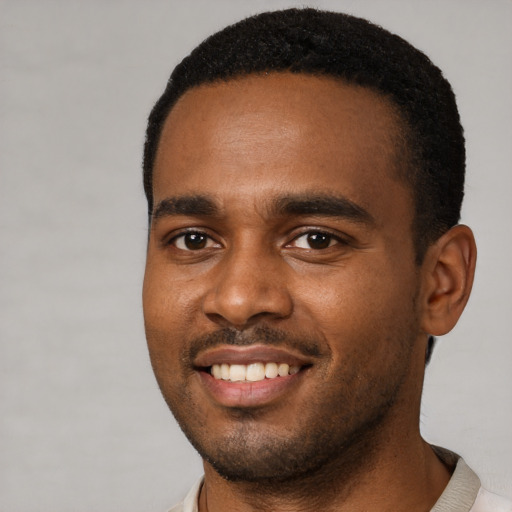 Joyful black young-adult male with short  brown hair and brown eyes