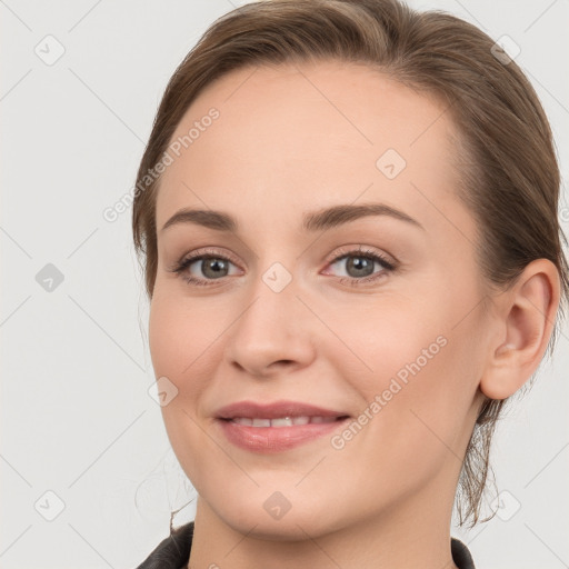 Joyful white young-adult female with medium  brown hair and grey eyes