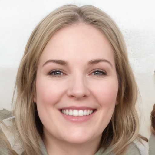 Joyful white young-adult female with long  brown hair and blue eyes