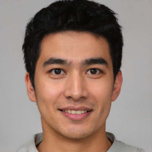 Joyful asian young-adult male with short  black hair and brown eyes