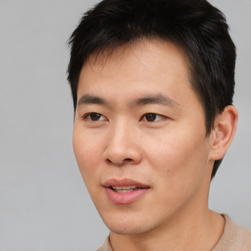 Joyful asian young-adult male with short  brown hair and brown eyes