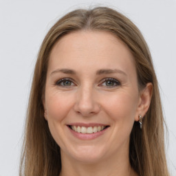 Joyful white young-adult female with long  brown hair and grey eyes