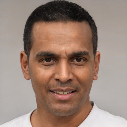 Joyful latino adult male with short  black hair and brown eyes