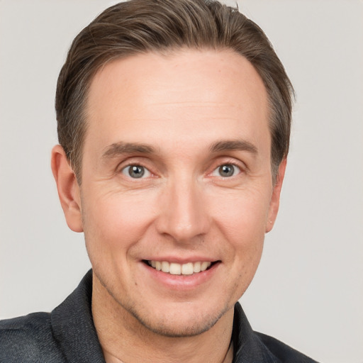 Joyful white adult male with short  brown hair and grey eyes