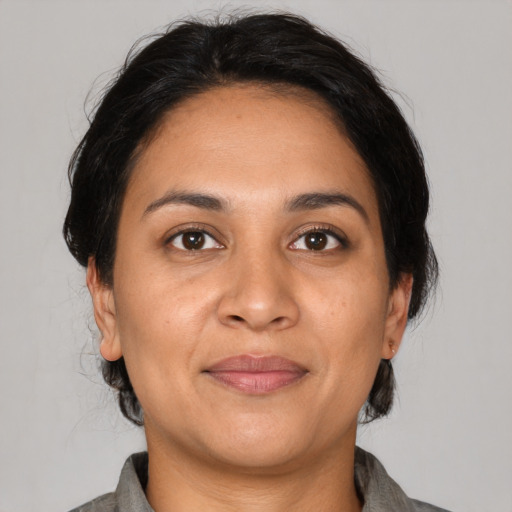 Joyful latino adult female with medium  black hair and brown eyes