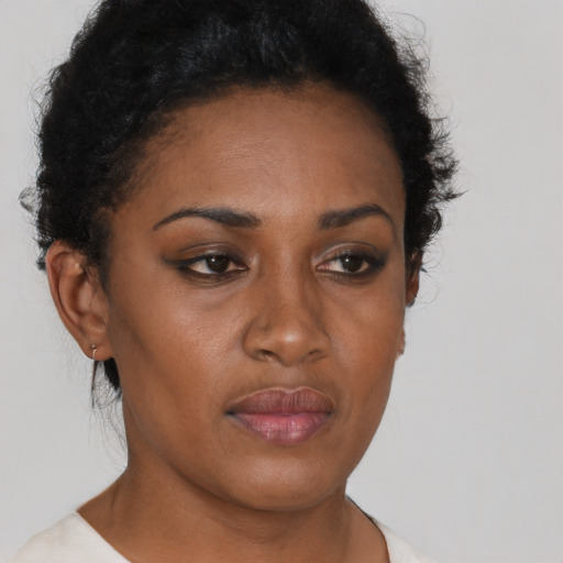 Joyful black young-adult female with short  brown hair and brown eyes
