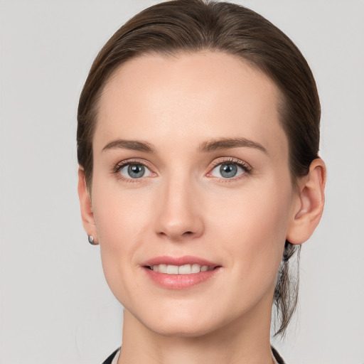 Joyful white young-adult female with medium  brown hair and grey eyes