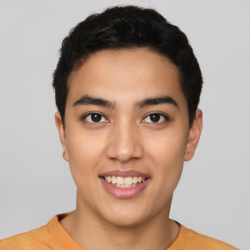 Joyful latino young-adult male with short  black hair and brown eyes