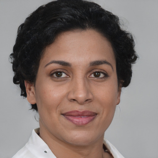 Joyful latino adult female with short  brown hair and brown eyes