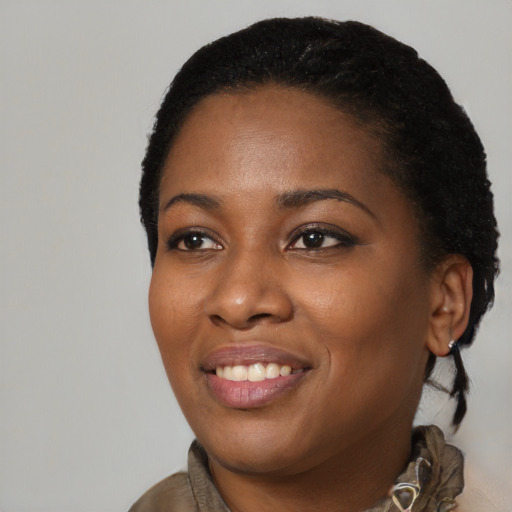 Joyful black young-adult female with short  black hair and brown eyes