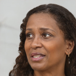 Joyful black adult female with long  brown hair and brown eyes