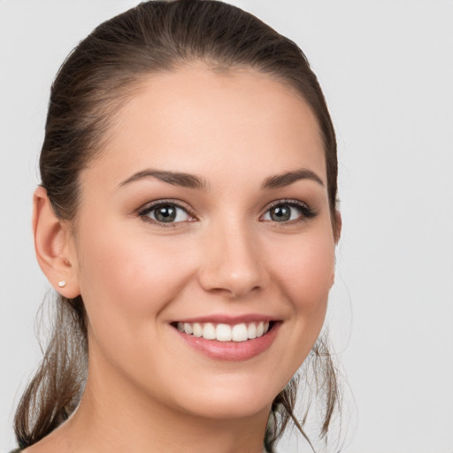 Joyful white young-adult female with medium  brown hair and grey eyes