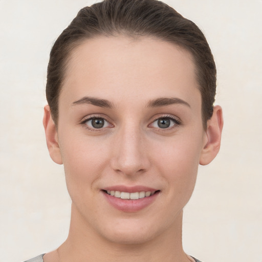 Joyful white young-adult female with short  brown hair and grey eyes