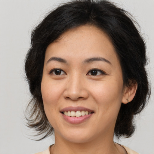 Joyful asian young-adult female with medium  brown hair and brown eyes