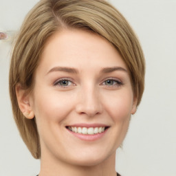 Joyful white young-adult female with medium  brown hair and grey eyes