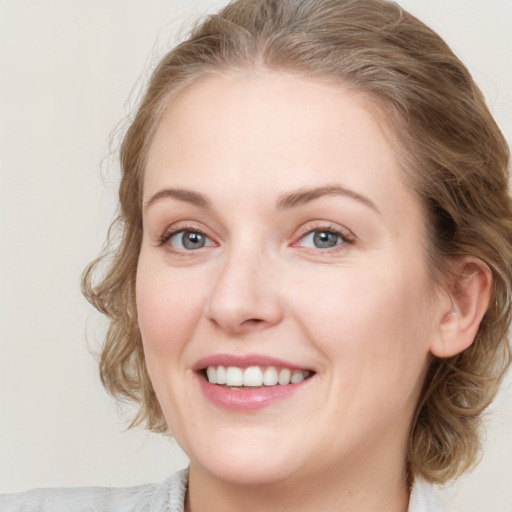 Joyful white young-adult female with medium  brown hair and blue eyes