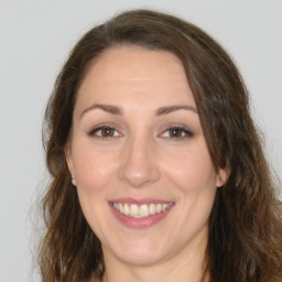 Joyful white adult female with long  brown hair and brown eyes