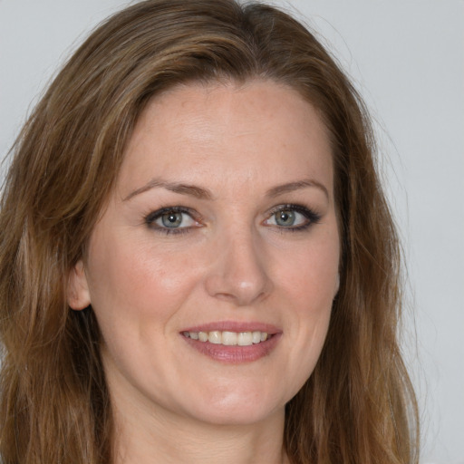 Joyful white young-adult female with long  brown hair and green eyes