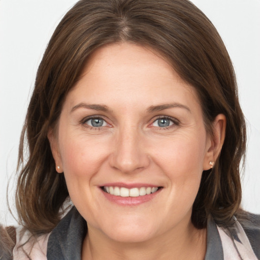 Joyful white adult female with medium  brown hair and grey eyes