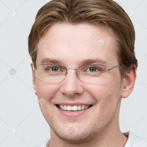 Joyful white young-adult male with short  brown hair and grey eyes