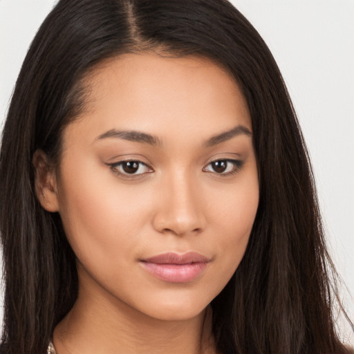 Joyful latino young-adult female with long  brown hair and brown eyes