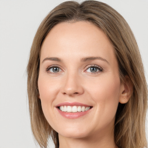 Joyful white young-adult female with long  brown hair and green eyes