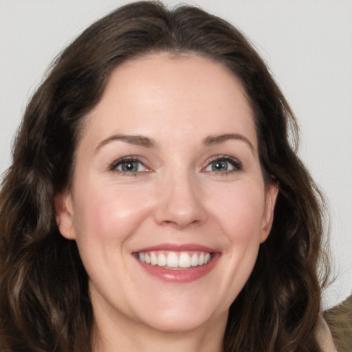 Joyful white adult female with long  brown hair and brown eyes