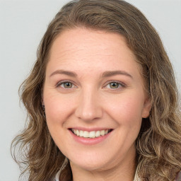 Joyful white young-adult female with long  brown hair and green eyes