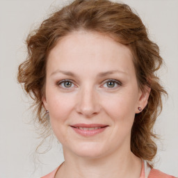 Joyful white young-adult female with medium  brown hair and blue eyes