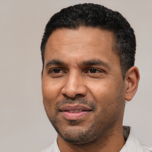Joyful latino adult male with short  black hair and brown eyes