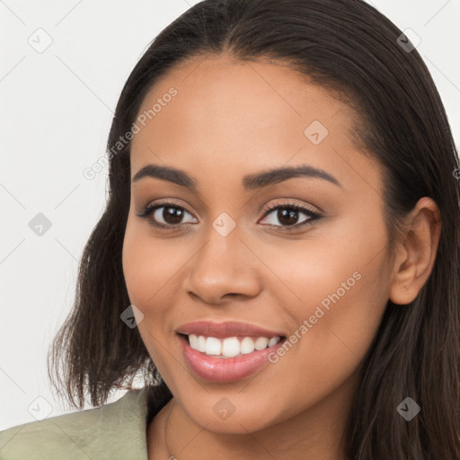 Joyful latino young-adult female with long  brown hair and brown eyes