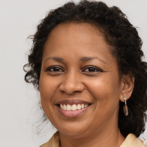 Joyful black adult female with medium  brown hair and brown eyes