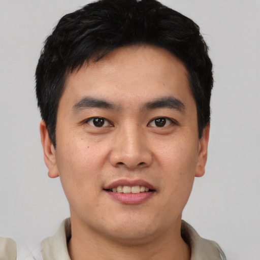 Joyful asian young-adult male with short  black hair and brown eyes