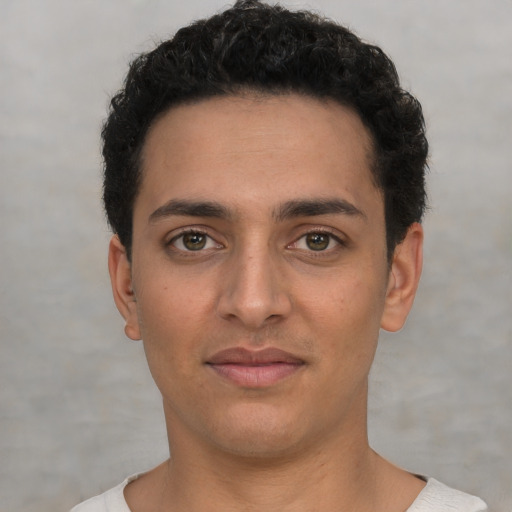 Joyful latino young-adult male with short  black hair and brown eyes