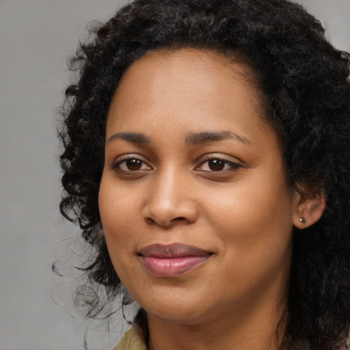 Joyful black young-adult female with long  black hair and brown eyes