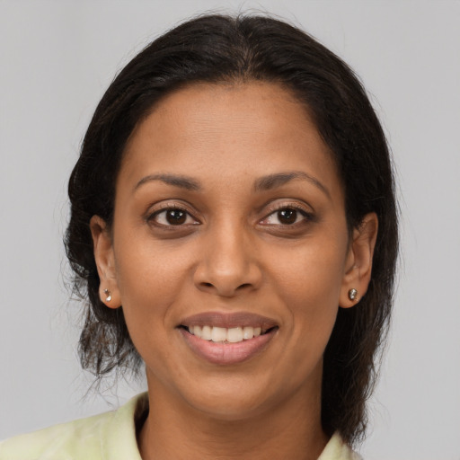 Joyful black young-adult female with medium  brown hair and brown eyes