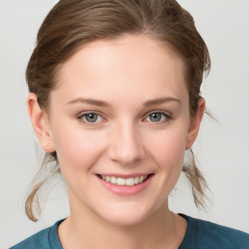 Joyful white young-adult female with medium  brown hair and blue eyes