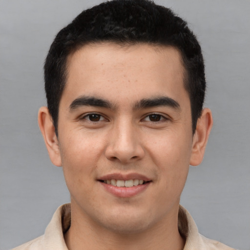 Joyful latino young-adult male with short  brown hair and brown eyes