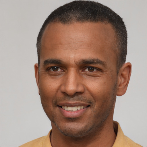 Joyful latino young-adult male with short  brown hair and brown eyes