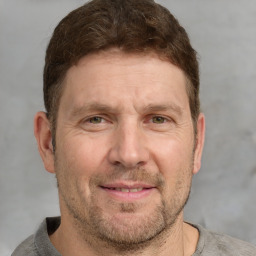 Joyful white adult male with short  brown hair and grey eyes